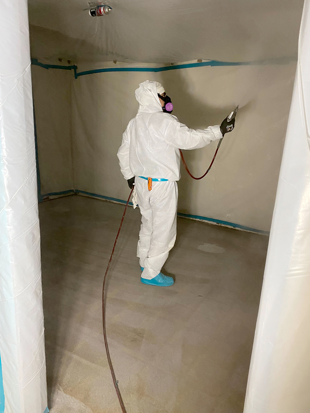 JJ&S technician working inside a sealed containment area