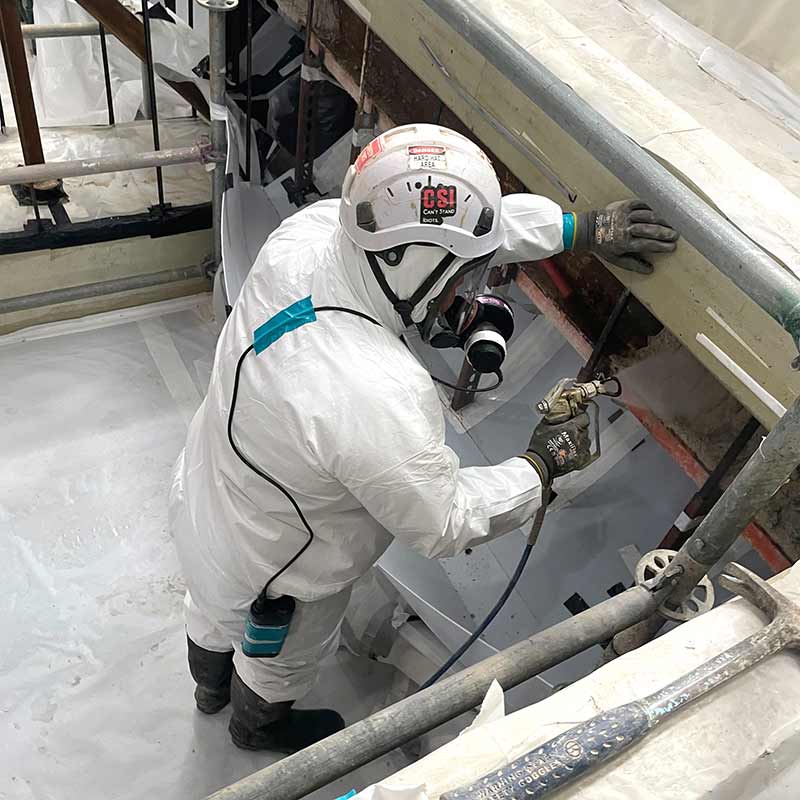 Asbestos abatement professional working inside the controlled project area